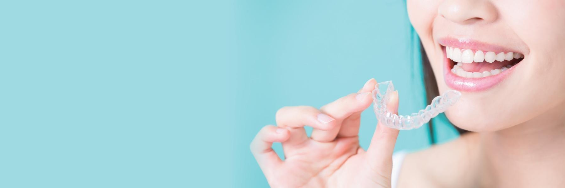 Woman holding tray of Invisalign clear braces in Aston PA